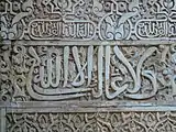 El lema nazarí ("No hay conquistador sino Dios") en caligrafía árabe cursiva, inscrito en el Salón de Embajadores de la Alhambra de Granada (siglo XIV)