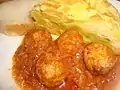 Almuerzo típico valenciano, plato con tortilla de patatas y albóndigas con salsa.