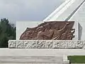 Relieve de bronce en la base que muestra al pueblo coreano.