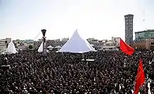 A crowd of mourning men in black clothing