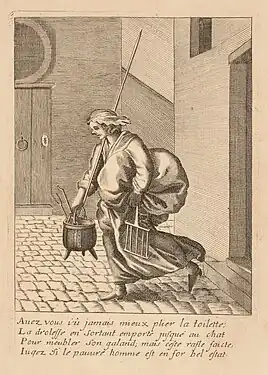 Une femme sort d'une maison dans la rue. Elle est chargée d'un gros ballot de tissus, d'une marmite, une fourche...