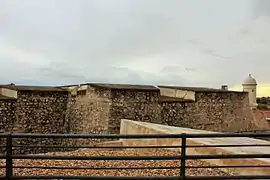 Tres lienzos en ángulo, garita, foso y troneras hacia en noroeste