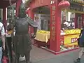 Estatua guardando un puesto de pato a la pequinesa.