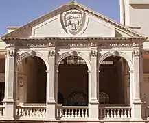 El escudo de armas del Estado en el balcón del tercer piso.