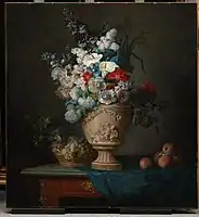 Ramo de flores en un jarrón de terracota con melocotones y uvas