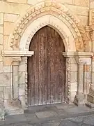 Puerta de entrada del claustro, con un arco puntiagudo proto-gótico, pero aún de época románica.