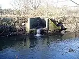 Un drenaje de agua superficial desemboca en el río Brent en la margen derecha.