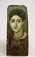 Joyas y peinados ayudan a datar los retratos femeninos. Esta joven muestra trenzas en pisos características de la época de Trajano, 98-117 d.C., así como aretes y un collar de perlas y esmeraldas.