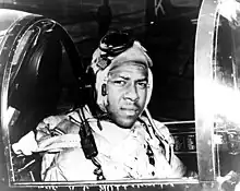 Un hombre afroamericano con ropa de piloto en la cabina de un avión.