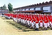 Tropa del CFN en forma para ceremonia festiva usando el uniforme "Alte. Alexandrino" que es formado por una mezcla de dos otros uniformes, la túnica roja (del uniforme garance) y a calza blanca del uniforme conocido como "Dolma blanco" o "blanco de Marina".