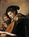 Dos niños cantando, con un cómplice a la izquierda.
