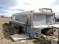 Vista frontal de un antiguo colectivo que es usado como vivienda en el asentamiento ilegal.