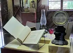 Vitrina con un libro de ejercicios para cítara, una ruleta para niños y otras piezas