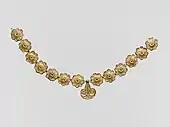 Collar de Micenas; 1400-1050 AC; terracotta dorada: diámetro de las rosetas: 2.7 cm, con variaciones de unos 0.1 cm, largo del pendiente 3.7 cm; Metropolitan Museum of Art (Nueva York)