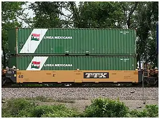 Un vagón pozo cargado con dos contenedores de cuarenta pies de la empresa Transportación Marítima Mexicana (TMM).