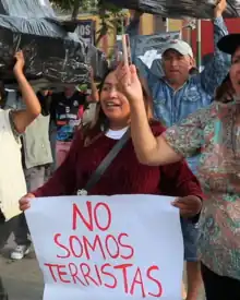 Mujer portando un cartel con el mensaje «No somos terroristas»