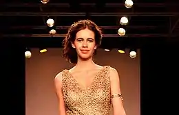  Koechlin llevando un vestido dorado.