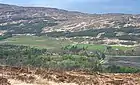 Kinloch en la cabecera de Loch Scresort, Rùm. Esta área ha proporcionado dos sitios de comienzos del Mesolítico. Una vista desde una elevación sobre los campos cultivados y un bosque mixto de coníferas y árboles caducifolios.
