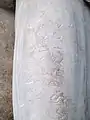 Inscripción en el muslo de la escultura.