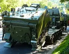 M-577A2 subiendo a una góndola de transporte