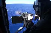 Se dispara una ametralladora M240D desde un SH-60F Sea Hawk