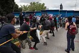 Personas intentando derribar la escultura el 12 de octubre de 2020.