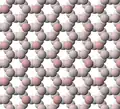 Vista de la estructura laminar tetraédrica del talco. Los iones de oxígeno apicales están teñidos de rosa.