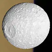Mimas por delante de los anillos de Saturno.