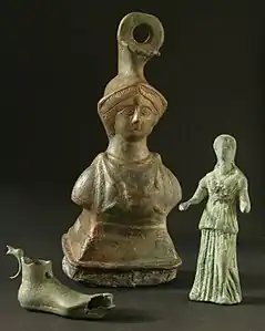 Tres objetos de bronce de antiguas colecciones: peso de balanza, lucerna en forma de pie, estatuilla de una figura femenina..