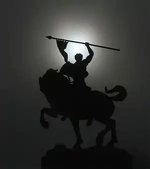 Estatua de El Cid silueteada por una corona solar en el frente del Legion