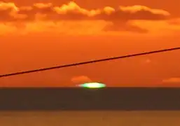 Destello verde casi perfecto. detalle ampliado del atardecer en Estreito da Calheta, Madeira, el 12 de diciembre de 2016.