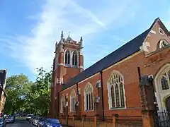 St Dionis (1884-1885), Parsons Green, Londres, torre completada en 1896, que muestra la nave lateral norte y la torre noreste, la iglesia tiene un estilo gótico perpendicular, menos típico de Christian