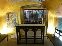 Vista de la Capilla de los Niños desde su entrada con su altar en el centro y los murales en muros dorados