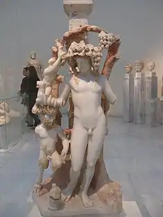 Dioniso con Pan. Un sátiro corta las uvas de la vid. El dios tiene una rima, Pan una corneta y Sátiro una hoz. Museo Arqueológico Nacional de Atenas. Taller de Asia Menor, mármol de la ciudad de Dokimio allí. 170-180 AD