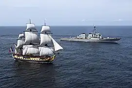 El USS Mitscher (DDG-57) navegando junto con el barco réplica Hermione en el año 2015.