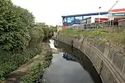 El río Brent en Vicar's Bridge, Alperton. Aquí, el río sirve como límite para dos distritos londinenses: Ealing (orilla izquierda) y Brent (orilla derecha).