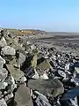 La orilla de Gortan, Loch Indaal mirando a lo largo del borde de la orilla durante la marea baja.