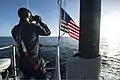 Un técnico de sonar está de guardia en la vela a bordo del Minnesota mientras el barco transita por Port Canaveral, FL.