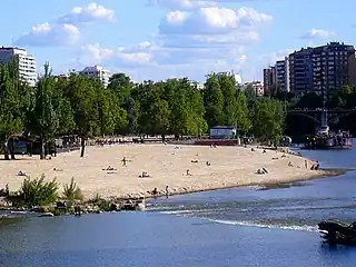 Vista de la playa de las Moreras, en el río  Pisuerga, a su paso por la ciudad de Valladolid, España en la que se aprecia la arena similar a las playas del litoral.