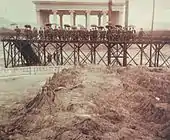 Miembros del Gabinete de Gobierno e invitados especiales observando el mapa. Al fondo, el Templo de Minerva.