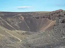 Un cráter profundo con rocas de color marrón