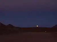 Salida de la luna sobre el camino de 12 m de ancho que conduce al Llano de Chajnantor.